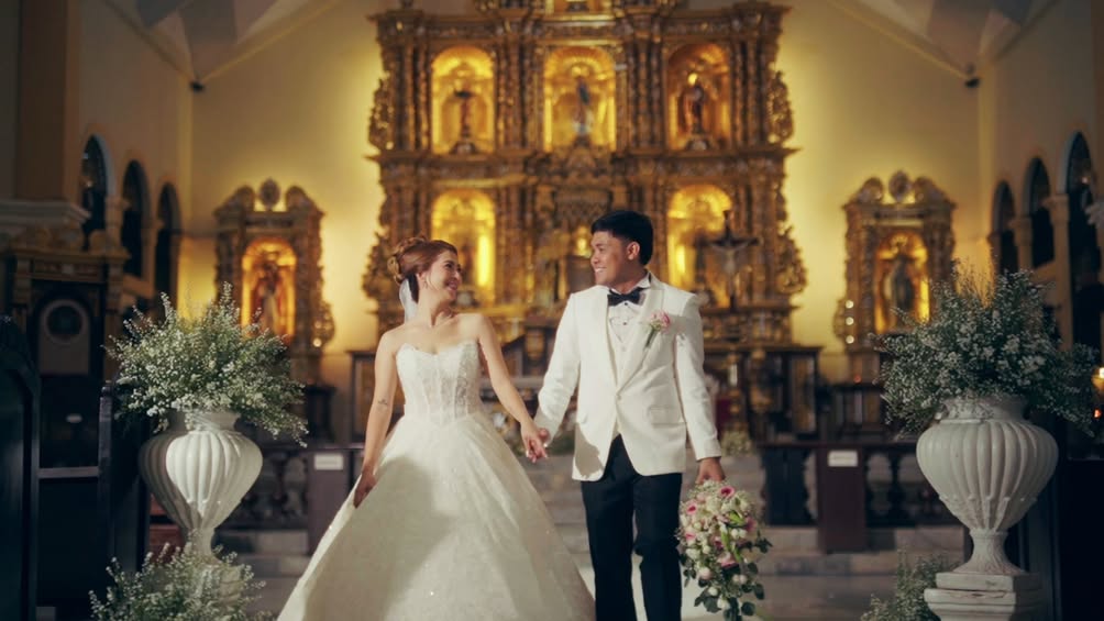 Basi and Erika holding hands in a warmly lit church